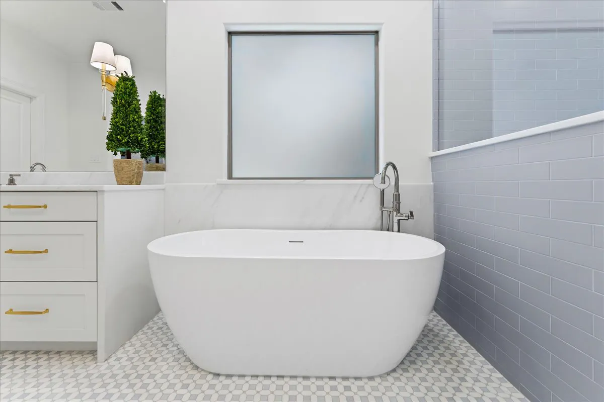 Marble slab backsplash behind a freestanding tub, with matching marble vanity counters, installed by Dallas Countertop