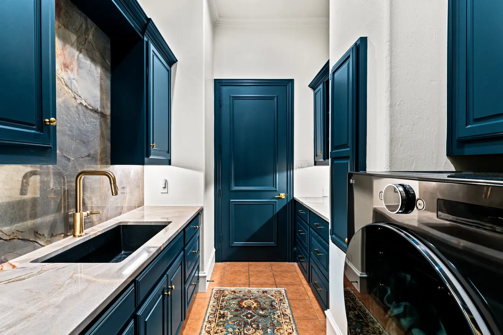Ijen Blue quartzite counters and slab backsplash in a navy laundry room in Dallas, TX