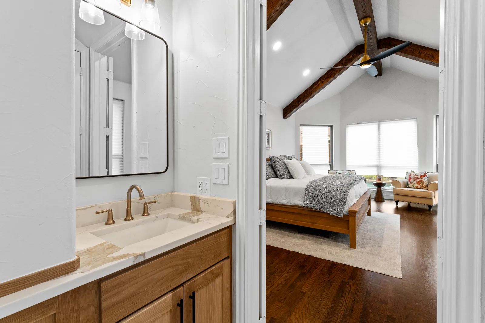 Quartzite vanity top with an undermount sink and brass faucet on white oak cabinetry in Plano, TX