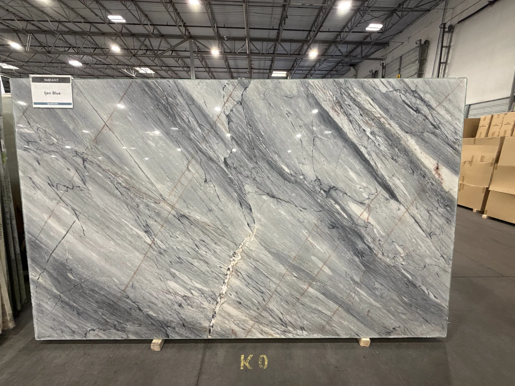 Ijen Blue quartzite: a whole slab in the yard, gray-blue with rust and white veining, selected by Dallas Countertop for a client